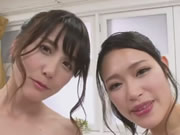 Twee Japanse natte meisjes bedienen een man in een bubbelbad